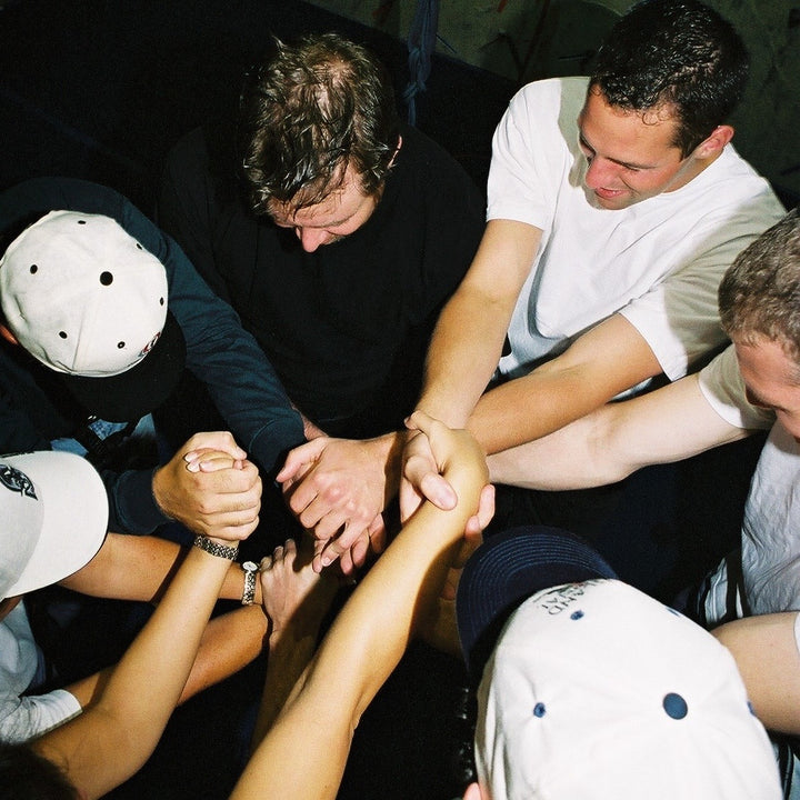 Group of climbers in a circle holding hands in the middle