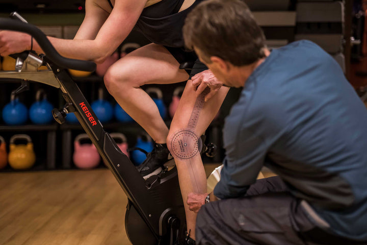 Personal trainer working with a client to optimize her training on the bike